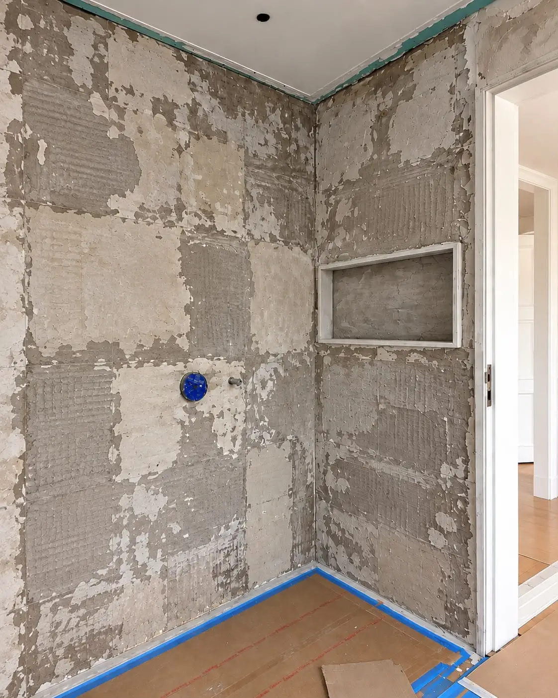 Shower area with the walls hacked back to the substrate and a recessed niche framed into the wall