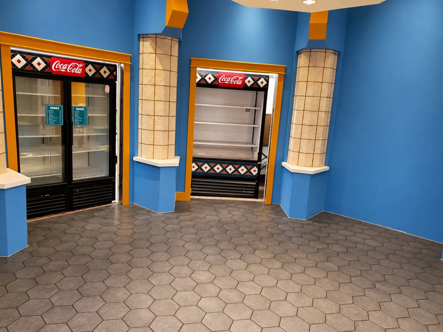 Retail interior with a hexagonal porcelain floor, columns clad in glazed tile and blue feature walls