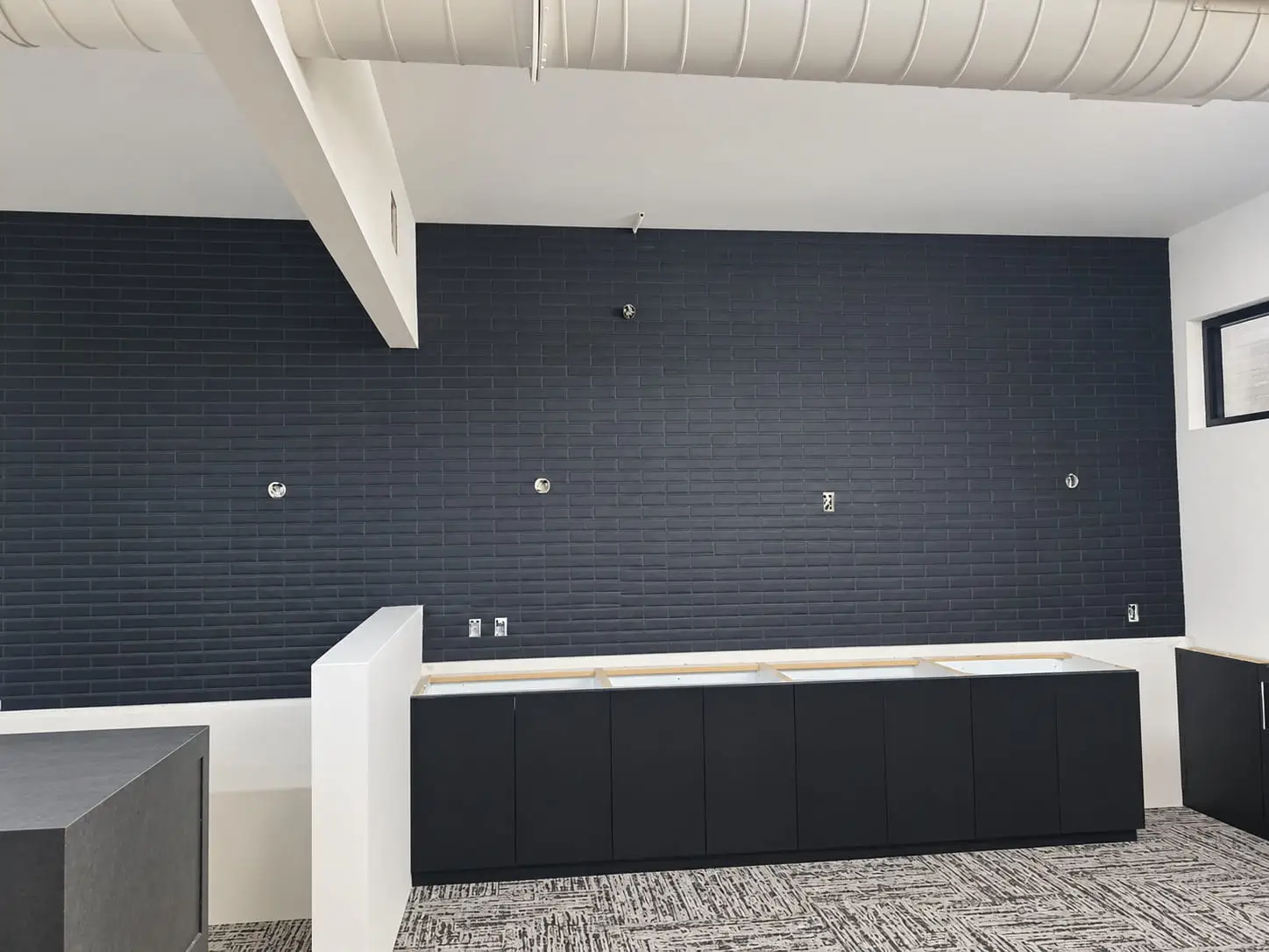 Service counter backed by a full-width wall of navy subway tile