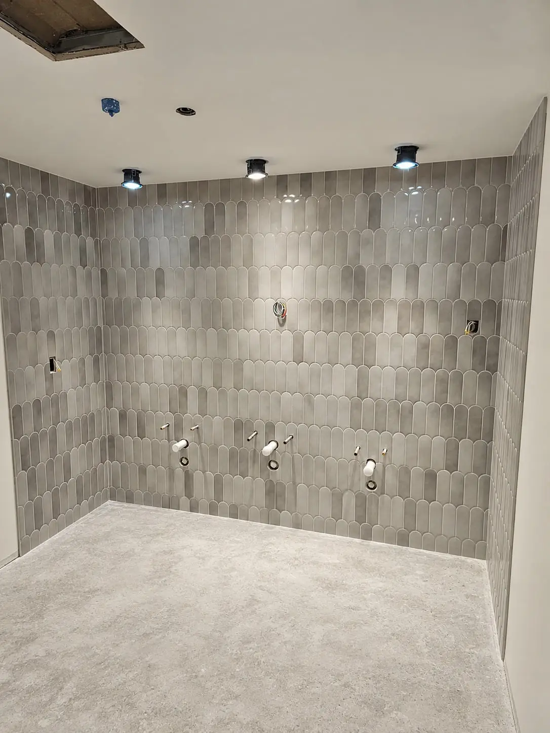 Shower wall in grey picket tile laid in a staggered pattern, ready for fixtures