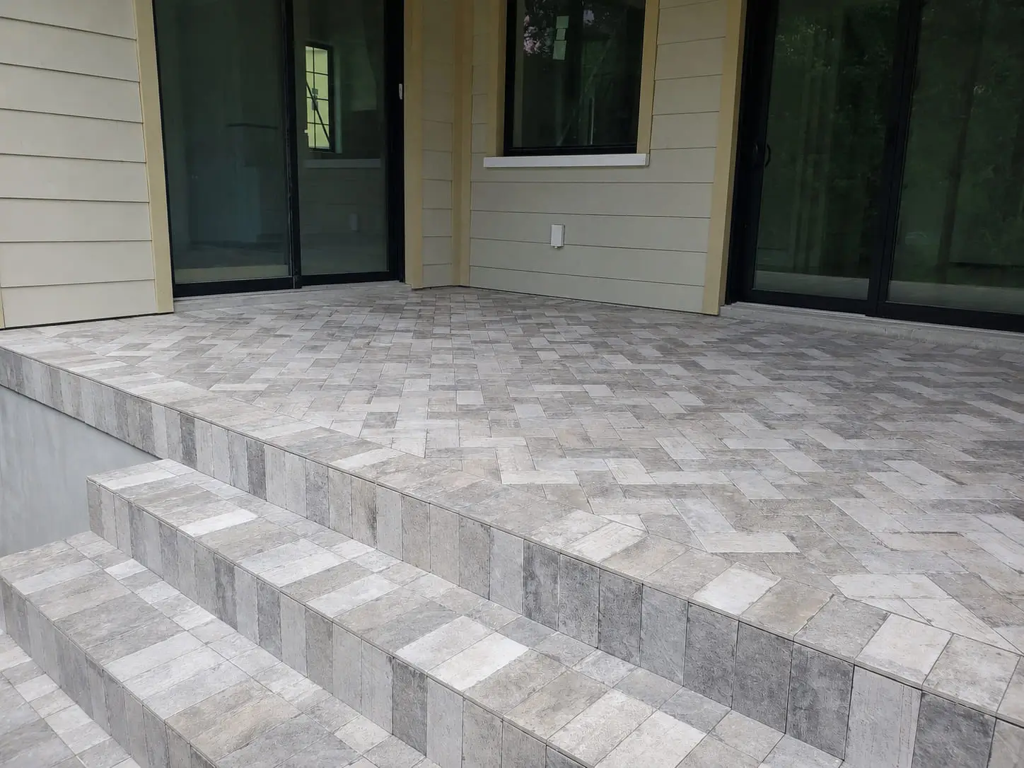 Paver terrace with steps running the full width, each tread levelled and the joints aligned across the run