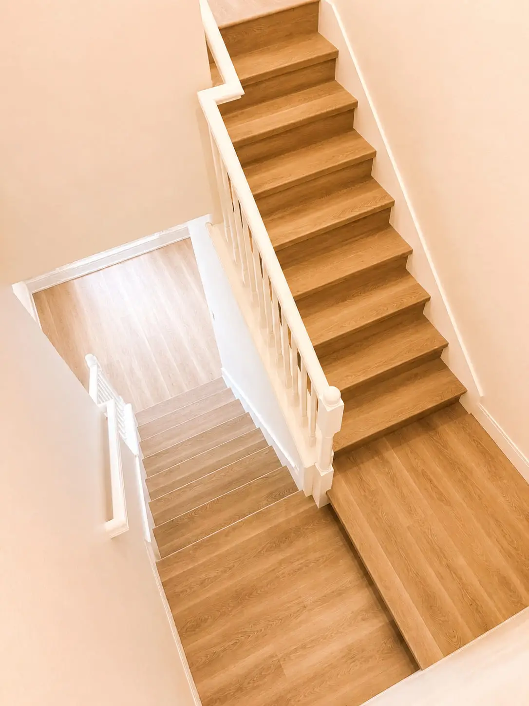 Full flight of oak stairs with white risers, meeting a matching floor at the top and bottom